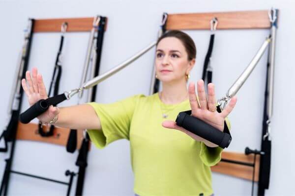 Dra. Raquel Pasqua, terapeuta fisioterapeuta reiki pilates radiestesia medicina germânica terapia Campinas, fazendo exercício de pilates. Um novo olhar para as dores físicas.