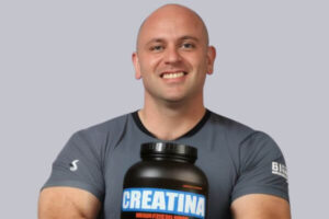 Leonardo Gobbi Personal Trainer segurando um pote de Creatina.